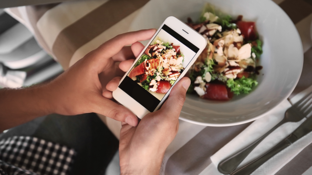 A Person Holding a Phone and Taking Picture of Food